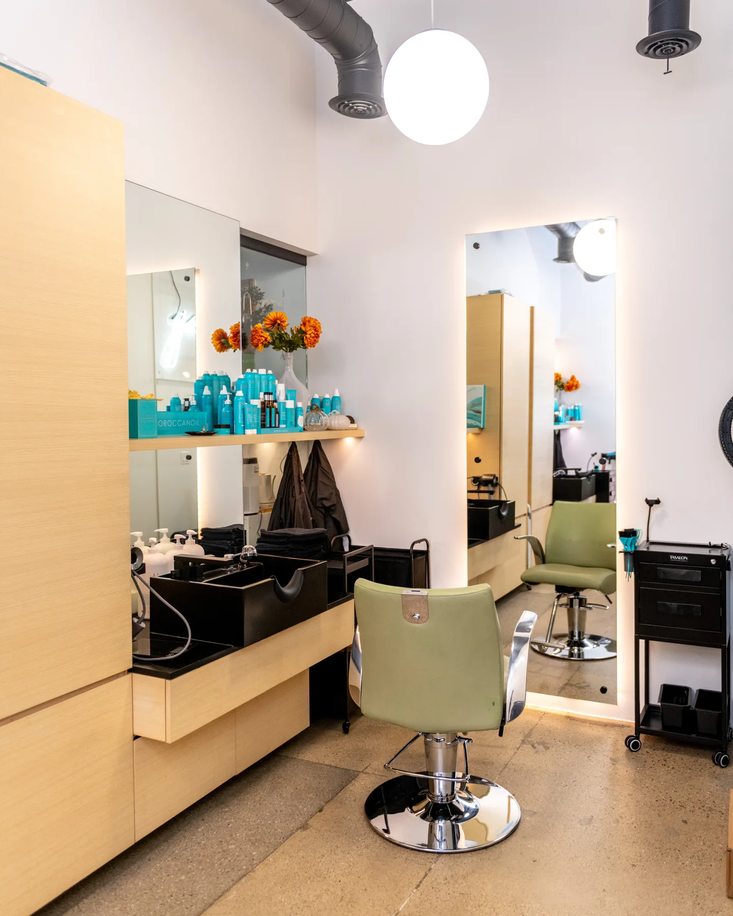 Styling chair, lit mirrors and Moroccanoil shelf inside Good Beauty Chicago