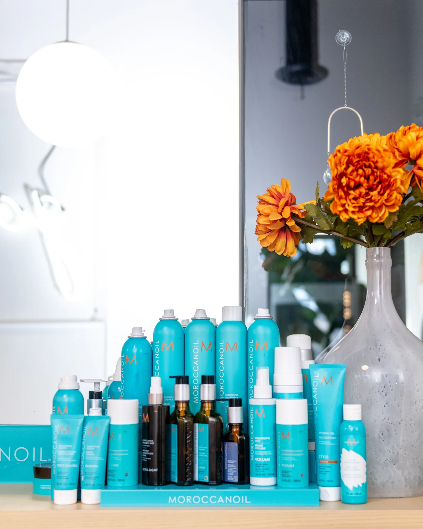 Moroccanoil product display with orange flowers at Good Beauty